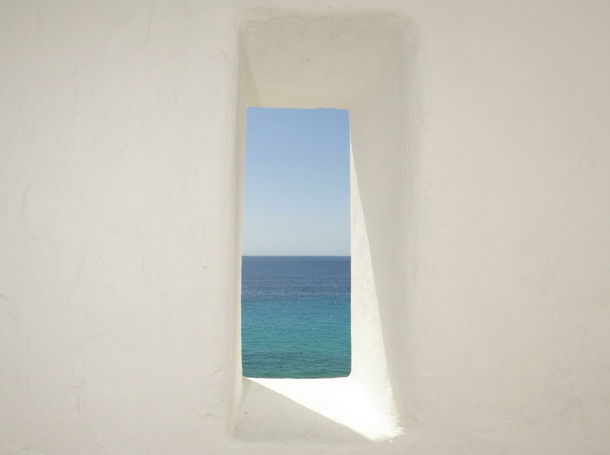 Linen curtain diffusing light against limestone wall